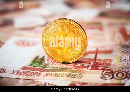 bitcoin coin se trouve sur le fond de roubles russes. Mining de crypto-monnaie et concept de minage. Vue de dessus, pose à plat. Banque D'Images