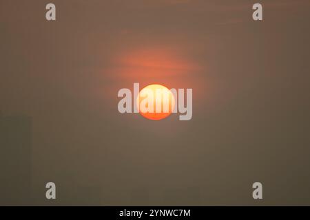 Coucher de soleil jetant des teintes dorées sur un ciel tranquille du soir dans une ville paisible Banque D'Images