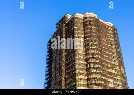 immeuble de grande hauteur en briques ensoleillé en rénovation au coucher du soleil d'automne Banque D'Images