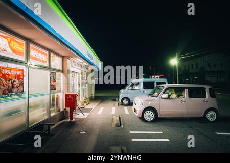Tokyo, Japon 12 août 2023 : Family Mart 24 7 combiné de nuit, avec deux kei voitures dans une scène nocturne typiquement japonaise. Banque D'Images