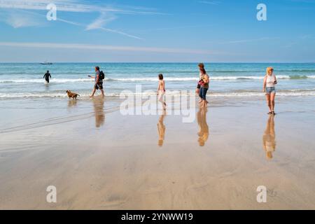 Vacanciers visiteurs appréciant une promenade le long du rivage à marée basse sur Towan Beach à Newquay en Cornouailles au Royaume-Uni. Banque D'Images