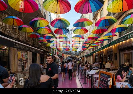 Lisbonne, Portugal - 8 septembre 2024 : les visiteurs profitent d'une atmosphère animée sous des parasols lumineux dans une rue animée de Lisbonne. Banque D'Images