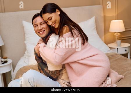 L'homme et la femme profitent d'un moment tendre ensemble, riant et s'embrassant dans une pièce légèrement éclairée. Banque D'Images