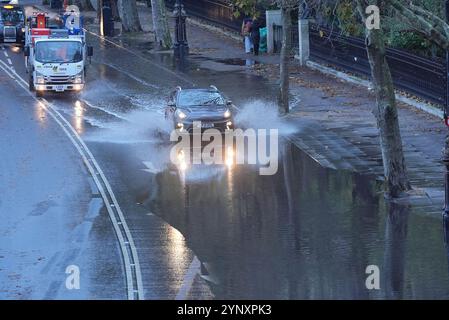 Les véhicules traversent les eaux de crue sur Victoria Embankment, dans le centre de Londres. Des trains ont été annulés dans certaines parties du sud de l'Angleterre après que de fortes pluies ont inondé les lignes de chemin de fer pendant la tempête Conall. Il arrive quelques jours seulement après que la tempête Bert a laissé des centaines de maisons inondées, transformé les routes en rivières et vu des vents de plus de 80 km/h. Date de la photo : mercredi 27 novembre 2024. Banque D'Images