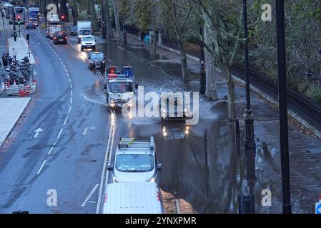 Les véhicules traversent les eaux de crue sur Victoria Embankment, dans le centre de Londres. Des trains ont été annulés dans certaines parties du sud de l'Angleterre après que de fortes pluies ont inondé les lignes de chemin de fer pendant la tempête Conall. Il arrive quelques jours seulement après que la tempête Bert a laissé des centaines de maisons inondées, transformé les routes en rivières et vu des vents de plus de 80 km/h. Date de la photo : mercredi 27 novembre 2024. Banque D'Images