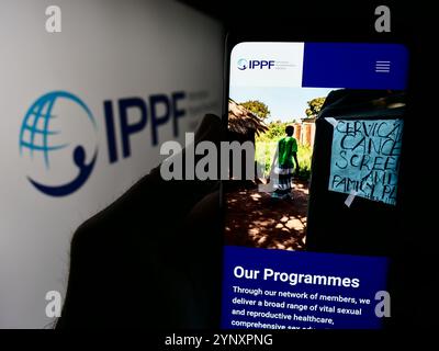 Dans cette illustration photo, une personne tient un smartphone avec le site Web de la Fédération internationale pour la planification familiale (IPPF) devant le logo. Banque D'Images