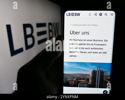 Dans cette illustration photo, une personne tient un smartphone avec la page web de la société allemande Landesbank Baden-Württemberg (LBBW) devant le logo. Banque D'Images