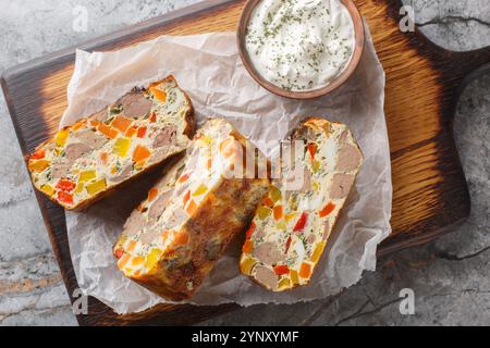 Cocotte de foie avec légumes, herbes et œufs gros plan sur une planche de bois sur la table. Vue horizontale de dessus Banque D'Images