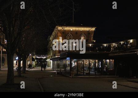 Rue nocturne à Sundsvall, Suède, avec cafés éclairés et architecture historique Banque D'Images