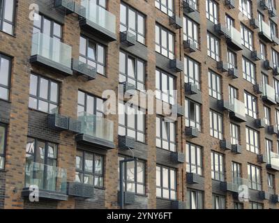 nouvelle maison en briques foncées construite avec balcons en verre, plein cadre de texture résident, fragment de façade de l'immeuble moderne appartement en perspective d'angle Banque D'Images