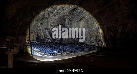 À l'intérieur du Parque Nacional Grutas de Cacahuamilpa, un remarquable auditorium creusé dans la grotte présente des rangées de sièges bleus entourés de rochers majestueux Banque D'Images