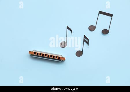 Composition avec harmonica et notes de musique sur fond de couleur Banque D'Images