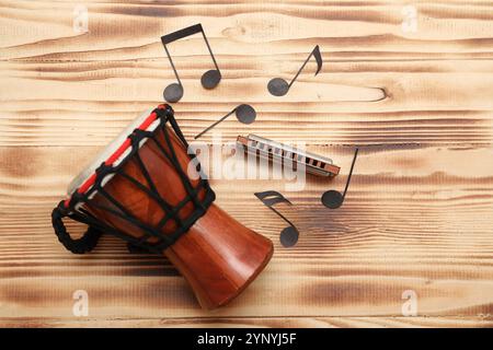 Composition avec harmonica, tambour et notes de musique sur fond de bois Banque D'Images