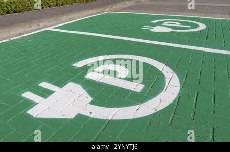 Place de parking avec symbole de charge pour voitures électriques Banque D'Images