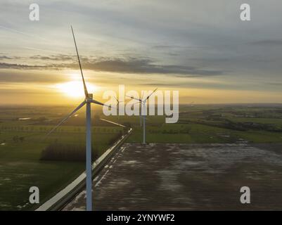 Plan aérien d'une rangée d'éoliennes au coucher du soleil Banque D'Images