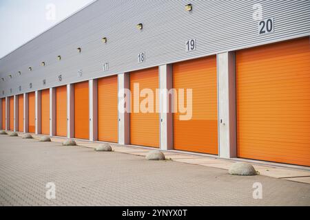 Extérieur d'un entrepôt commercial avec portes roulantes orange Banque D'Images