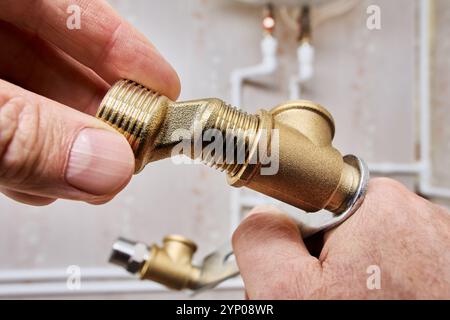 Taraud mâle les pattes du réducteur excentrique vissées dans le support de montage du robinet de douche. Banque D'Images