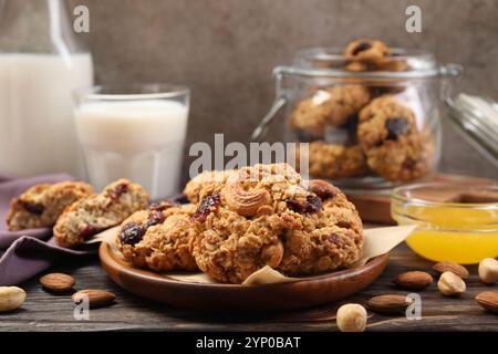 Délicieux biscuits à l'avoine avec raisins secs et noix servis sur une table en bois Banque D'Images