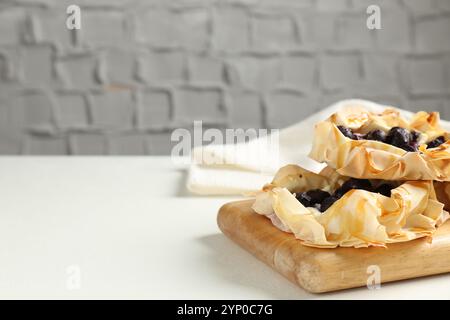 Délicieuses pâtisseries feuilletées aux myrtilles sur une table blanche à l'intérieur, espace pour le texte Banque D'Images