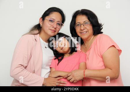 Trois générations de femmes brunes Latina, grand-mère, maman et fille avec des lunettes montrent leur amour et le soutien de leur famille célèbrent la fête des mères Banque D'Images