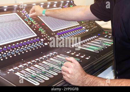 Ingénieur du son mains ajustant le mixeur de son de contrôle dans l'enregistrement, studio de diffusion Banque D'Images