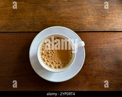Vue de dessus d'une tasse de thé au lait ou teh tarik sur une table en bois Banque D'Images