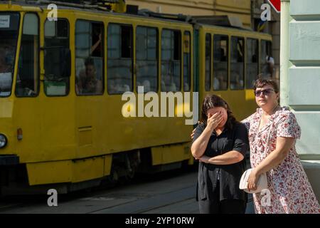 03.09.2024, Ukraine, oblast de Lviv, Lviv - guerre ukrainienne : le tram arrêté pour un cortège funèbre pour deux soldats ukrainiens tombés au combat. Devant deux tristes wome Banque D'Images