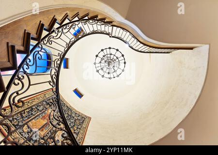 Escalier en colimaçon élégant avec balustrade complexe et lustre Banque D'Images