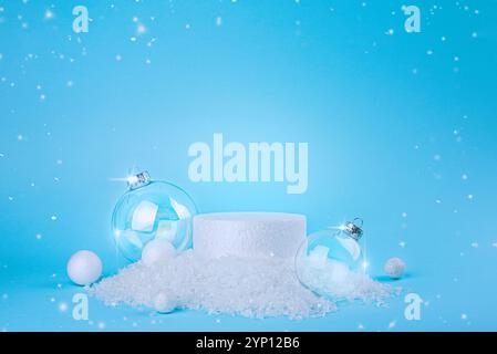 Podium festif avec des ornements en verre et des flocons de neige sur un fond bleu Banque D'Images