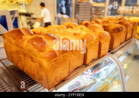 pain exposé par le boulanger. Pains à croûte dorée. Assortiment de pains. pâtisseries fraîches sur le comptoir dans le magasin. Banque D'Images