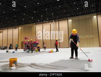 (241128) -- BEIJING, 28 novembre 2024 (Xinhua) -- des membres du personnel effectuent des travaux de nettoyage à l'intérieur d'un centre de congrès et d'exposition dans le cadre de la deuxième phase du projet du Centre national de congrès de Chine, à Beijing, capitale de la Chine, 28 novembre 2024. Le centre de congrès et d'exposition, le bâtiment principal du projet de deuxième phase du Centre national de congrès de Chine, a passé avec succès l'évaluation d'achèvement et l'évaluation de contrôle de feu ces derniers jours. Toutes les installations du centre ont atteint la norme pour le fonctionnement pratique pour accueillir divers types d'événements. Une fois l'opération terminée, le m Banque D'Images