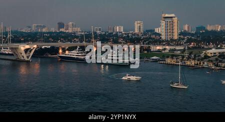 Fort Lauderdale, États-Unis - 29 décembre 2017 : vue en soirée des yachts et des bateaux amarrés près d'un pont avec la ligne d'horizon de la ville en arrière-plan. Banque D'Images