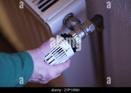 Eine Frauenhand dreht an einem Thermostatkopf an einem Heizkörper Heizkörper. Der Thermostatkopf steht auf Stufe 3. Symbolbild zum Thema Energiekosten AM 28.11.2024 in Siegen/Deutschland *** Une main de femme tourne une tête thermostatique sur un radiateur radiateur radiateur la tête thermostatique est réglée au niveau 3 image symbolique sur le sujet des coûts énergétiques sur 28 11 2024 in Siegen Allemagne Banque D'Images