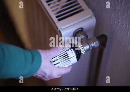 Eine Frauenhand dreht an einem Thermostatkopf an einem Heizkörper Heizkörper. Der Thermostatkopf steht auf Stufe 3. Symbolbild zum Thema Energiekosten AM 28.11.2024 in Siegen/Deutschland *** Une main de femme tourne une tête thermostatique sur un radiateur radiateur radiateur la tête thermostatique est réglée au niveau 3 image symbolique sur le sujet des coûts énergétiques sur 28 11 2024 in Siegen Allemagne Banque D'Images