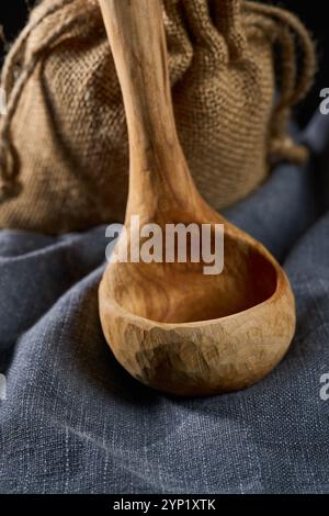 Louche en bois de cerisier sculptée à la main sur un tissu gris en gros plan Banque D'Images