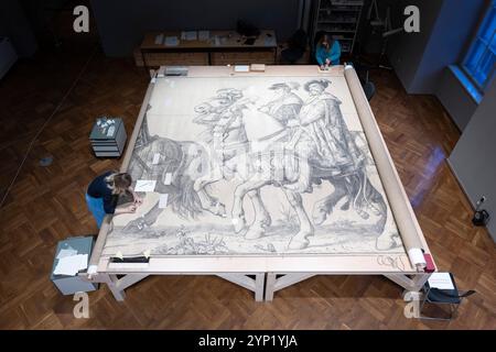 Dresde, Allemagne. 28 novembre 2024. Les restaurateurs travaillent sur les dessins préliminaires du train royal dans le palais japonais. La restauration du dessin à l'échelle 1:1 du monument de Dresde devrait être achevée d'ici août 2025. Crédit : Sebastian Kahnert/dpa/Alamy Live News Banque D'Images