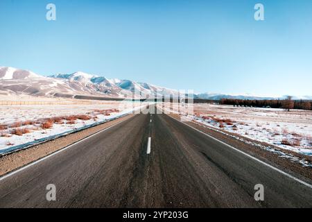 Paysage routier en montée en hiver à Islande. Route asphaltée avec des côtés pleins de neige Banque D'Images