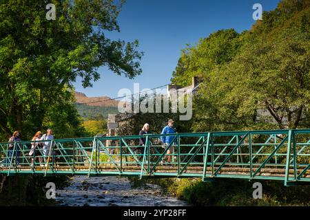 Royaume-Uni, pays de Galles, Gwynedd, Snowdonia, Beddgelert, les visiteurs traversent le pont de fer sur la rivière Afon Glaslyn Banque D'Images