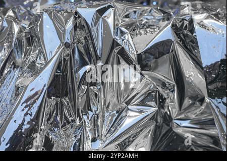 Feuille de papier d'argent froissée froissée avec de la neige comme texture ou fond de Noël, nouvel an Banque D'Images