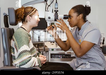 Ophtalmologiste femme examinant l'oeil d'une patiente en clinique hospitalière Banque D'Images