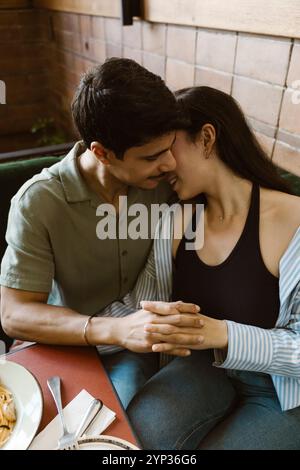 Vue en angle élevé d'un couple romantique avec les mains entrelacées au restaurant Banque D'Images