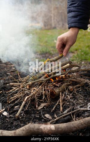 L'homme allume un feu dans la forêt Banque D'Images