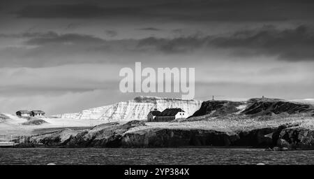 Paysage panoramique avec des montagnes côtières enneigées sous un ciel spectaculaire. Région de Reykjavik, Islande. Photographie noir et blanc Banque D'Images