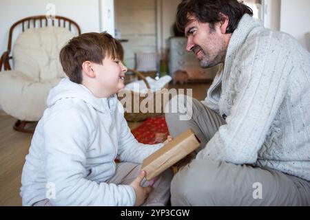 23 novembre 2024 : image symbolique pour un moment spécial de lien familial : un enfant présente fièrement à son père un cadeau - un symbole d'affection, d'amour et de don dans la famille. Un précieux moment de proximité. *** Symbolbild für einen besonderen moment der Familienbindung : Ein Kind beschenkt stolz seinen Vater ein Symbol für Zuneigung, Liebe und das Geben in der Familie. Ein wertvoller Augenblick der Verbundenheit. Banque D'Images