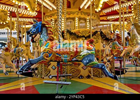 Chevaux de carrousel en manège à la foire de Noël à George Street, Édimbourg, Écosse, Royaume-Uni. Banque D'Images