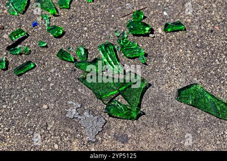 Verre vert brisé sur le sol en béton Banque D'Images