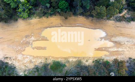 Photographie aérienne par drone d'une inondation sur une piste de terre traversant le Bush causée par les fortes précipitations dans les Blue Mountains en Australie. Banque D'Images