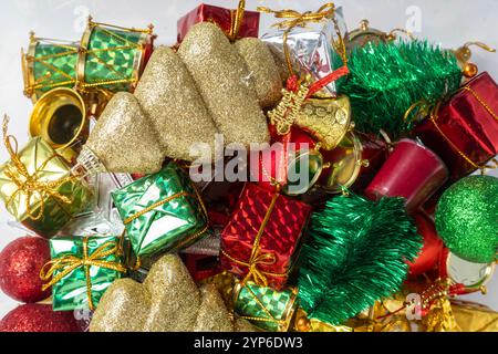 Vue de dessus des décorations de Noël colorées avec ornements brillants, cadeaux miniatures et boules. Parfait pour les designs saisonniers, promo de vacances Banque D'Images