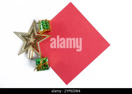 Un bel arrangement mettant en vedette une étoile de Noël, des cadeaux magnifiquement emballés et du papier rouge vif, sur un fond blanc propre. Parfait pour Banque D'Images