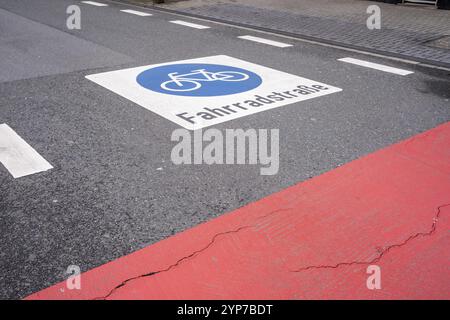 Piste cyclable marquée sur la route par des symboles peints en rouge et en blanc Banque D'Images